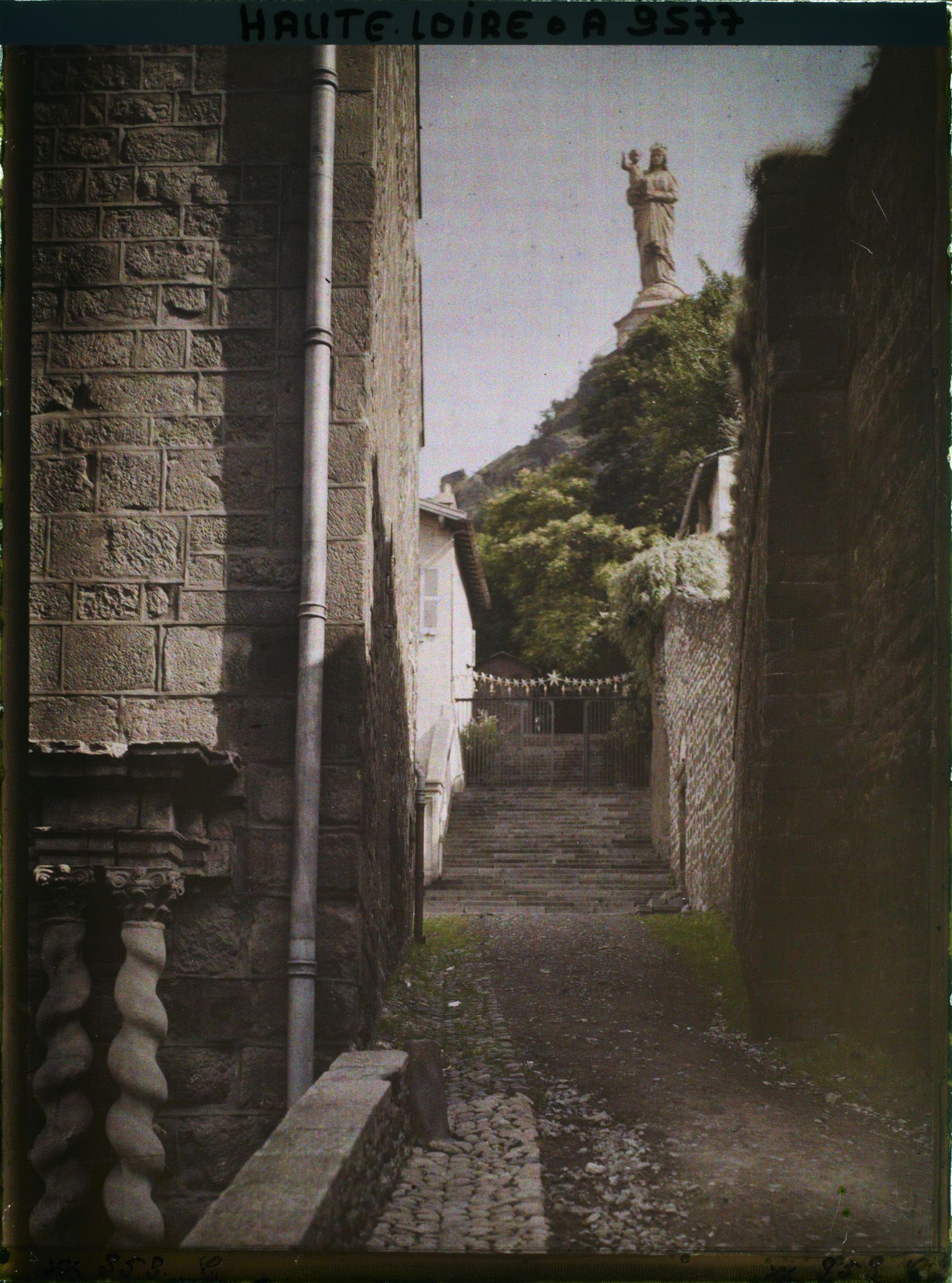 Image représentant La rue du Cloître dominée par la statue de Notre-Dame-de-France érigée au sommet du rocher Corneille