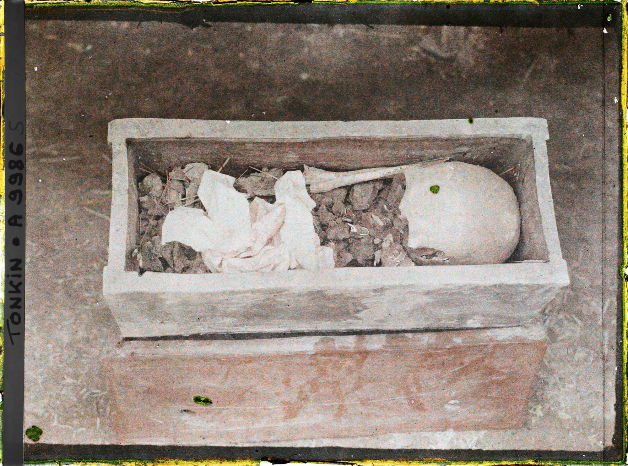 Image représentant Le cercueil en terre cuite, sans couvercle, où sont rassemblés les ossements du défunt après l'exhumation, lors d'une pratique funéraire (changement de sépulture)
