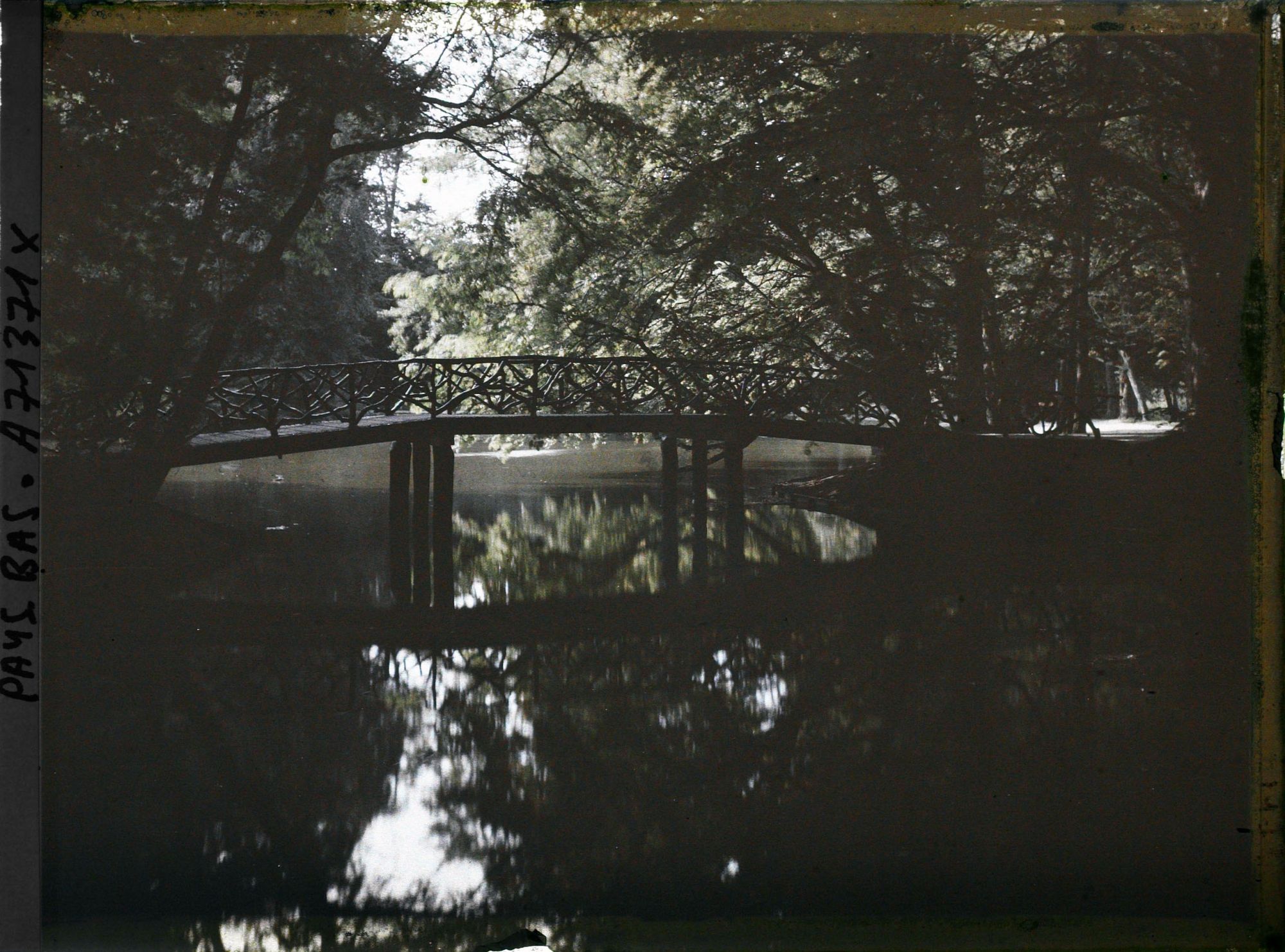 Image représentant Petit pont traversant une pièce d'eau ou un canal dans un parc