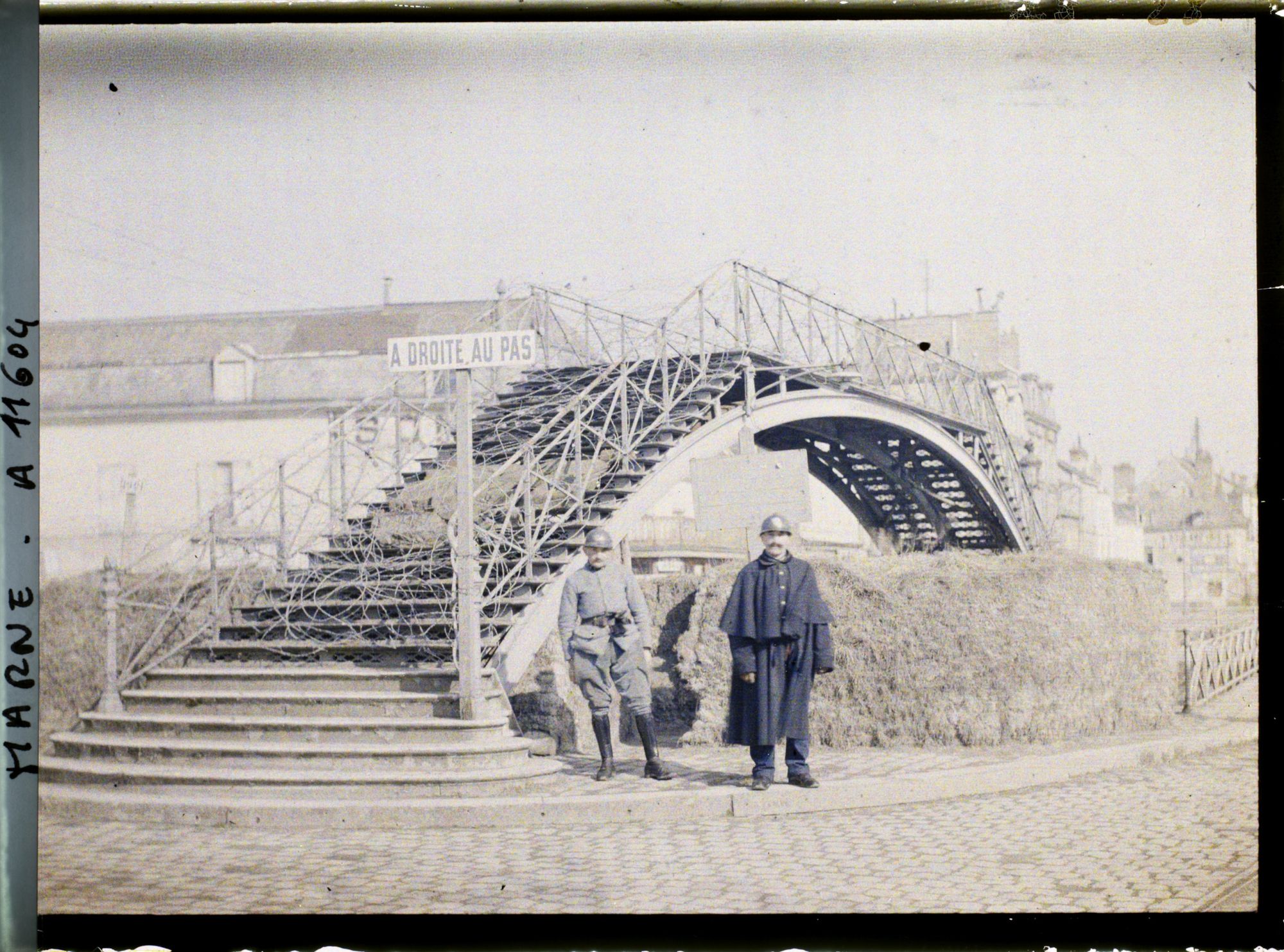 Image représentant Deux soldats devant un pont couvert de barbelés