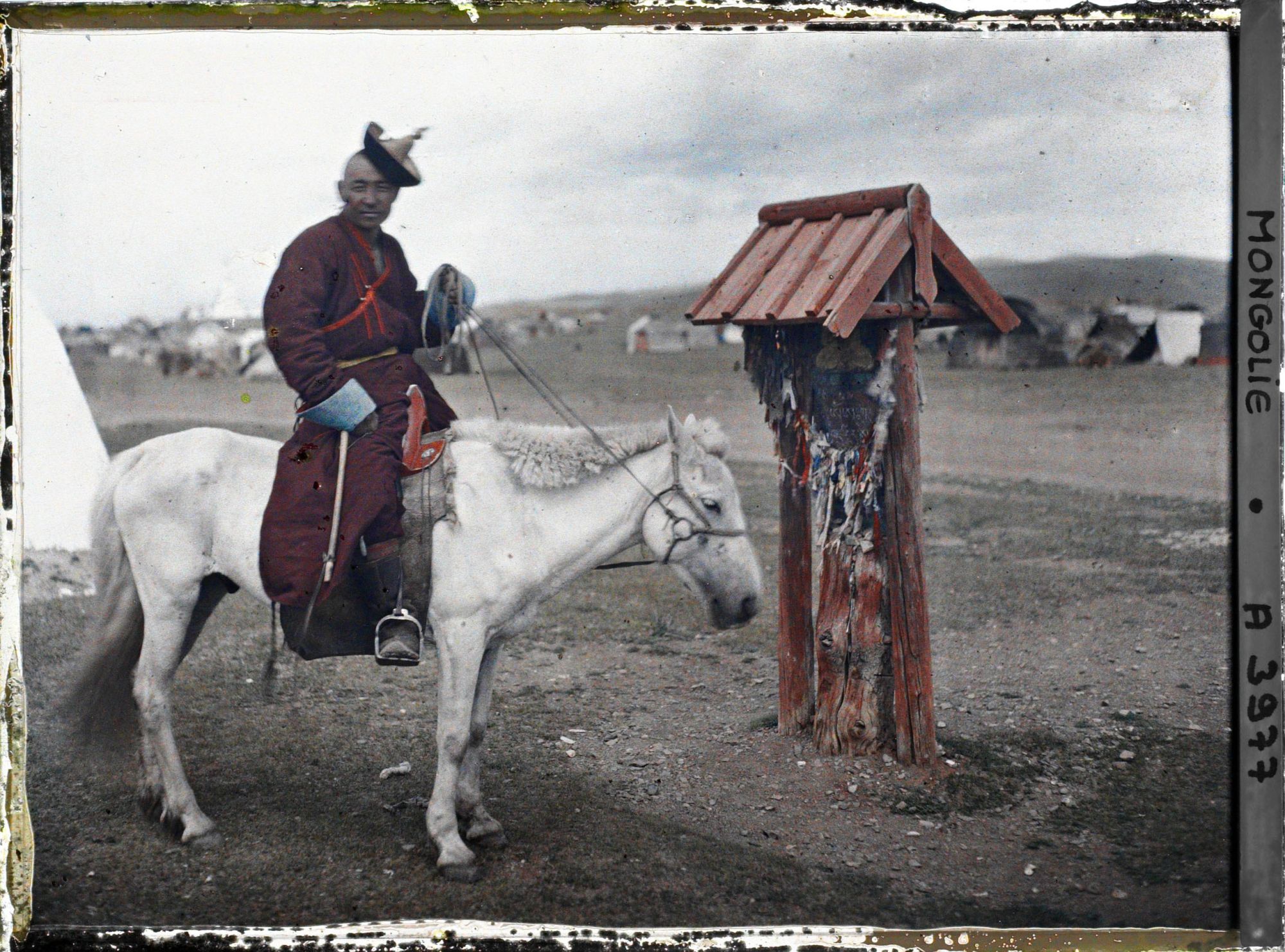 Image représentant Un lama à cheval près d'un petit monument votif