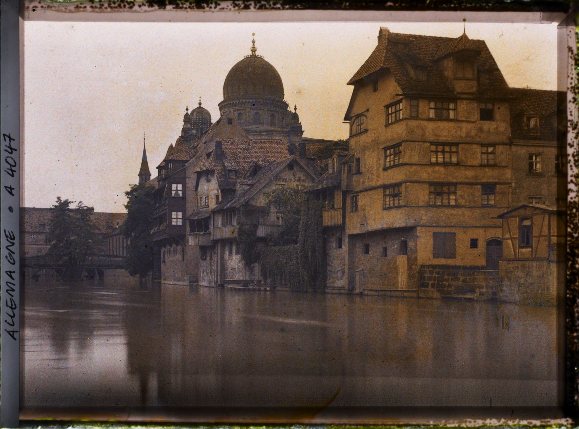Image représentant Maisons anciennes au bord de la Pegnitz, avec les coupoles de la synagogue à l'arrière-plan