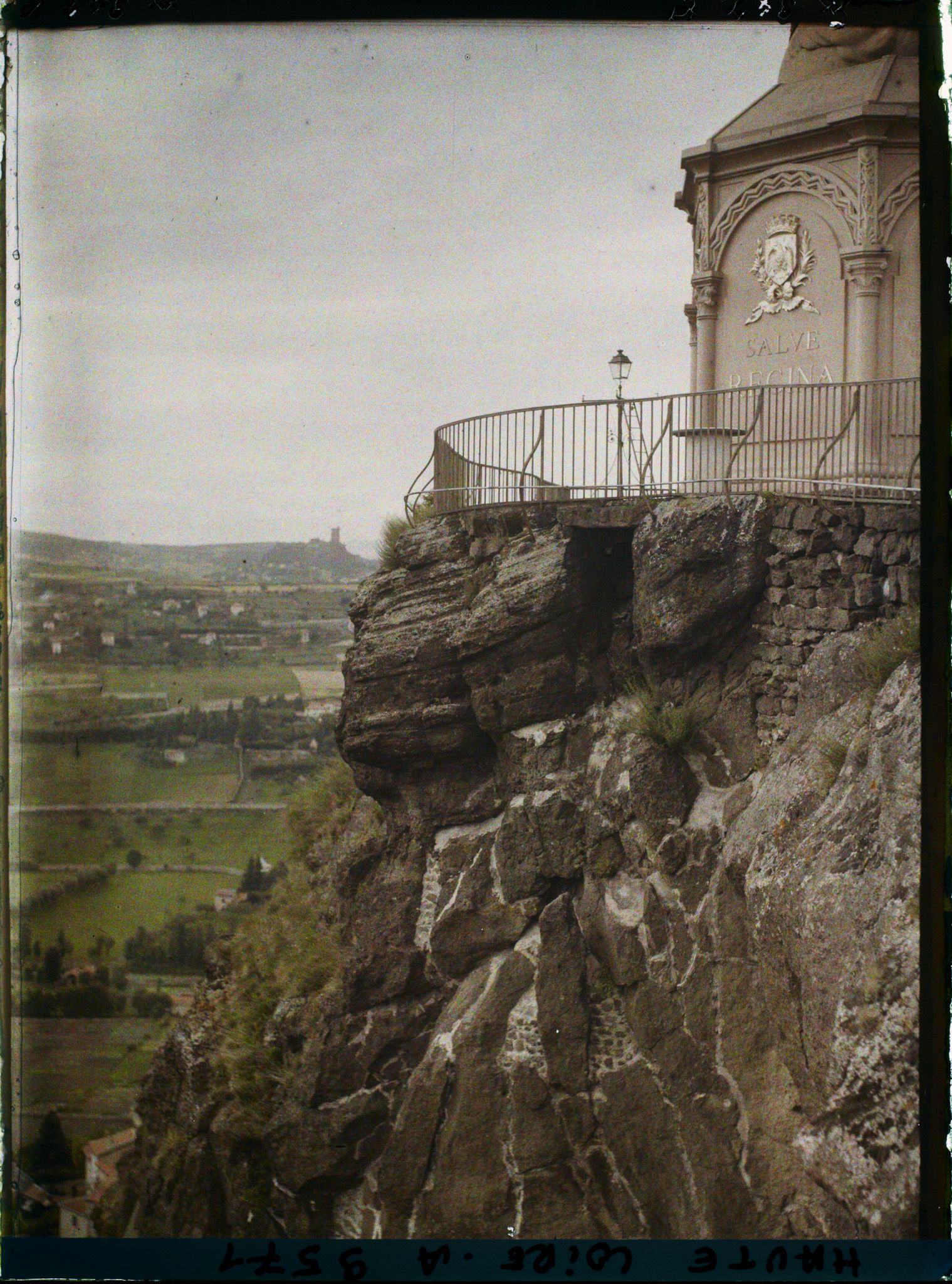 Image représentant Le sommet du rocher Corneille avec le piedestal de la statue de Notre-dame-de-France et dans le lointain la silhouette du château de Polignac