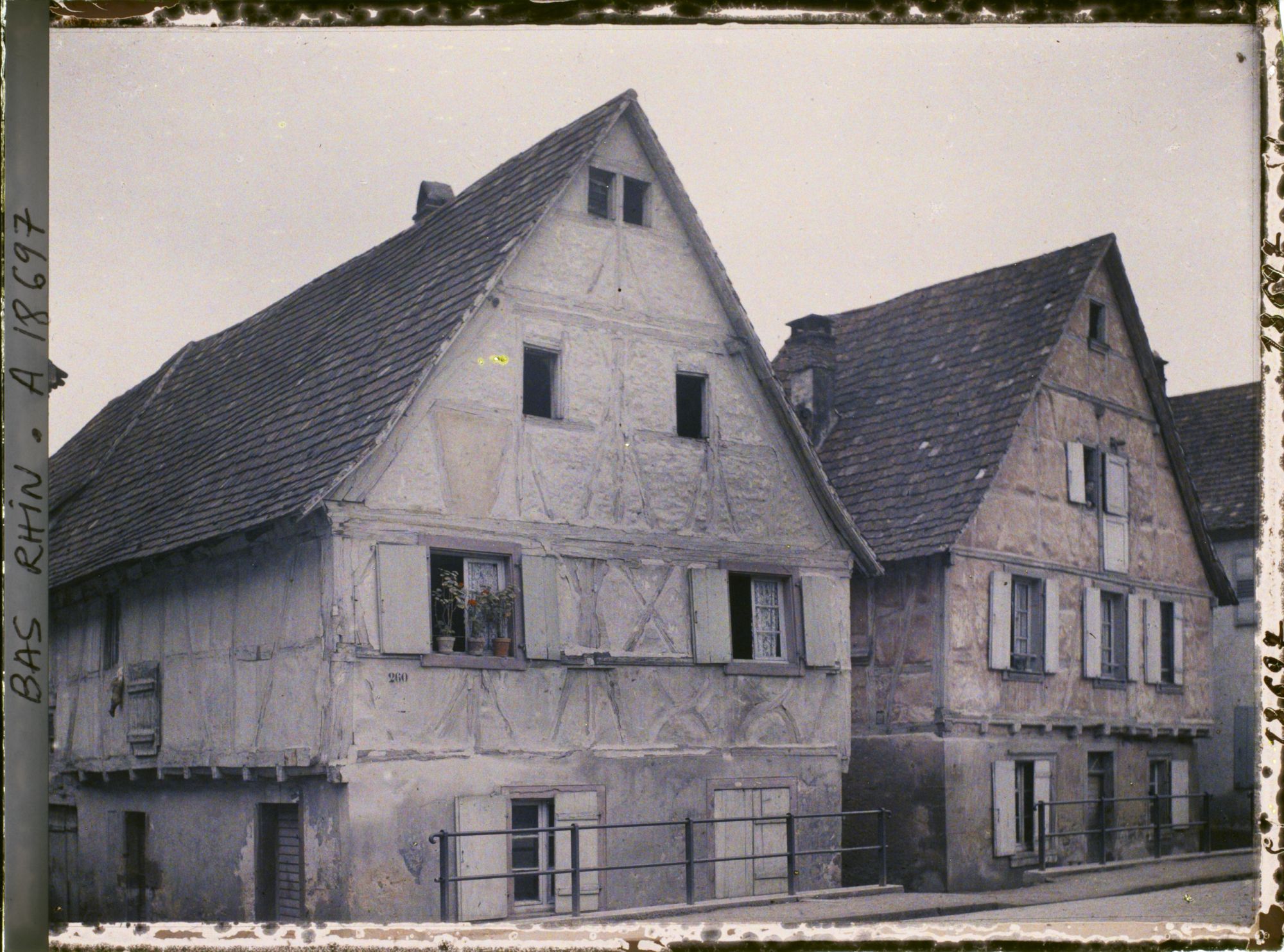 Image représentant France, Marmoutier, Dans la rue qui conduit vers Strasbourg, maison grise et maison rouge.