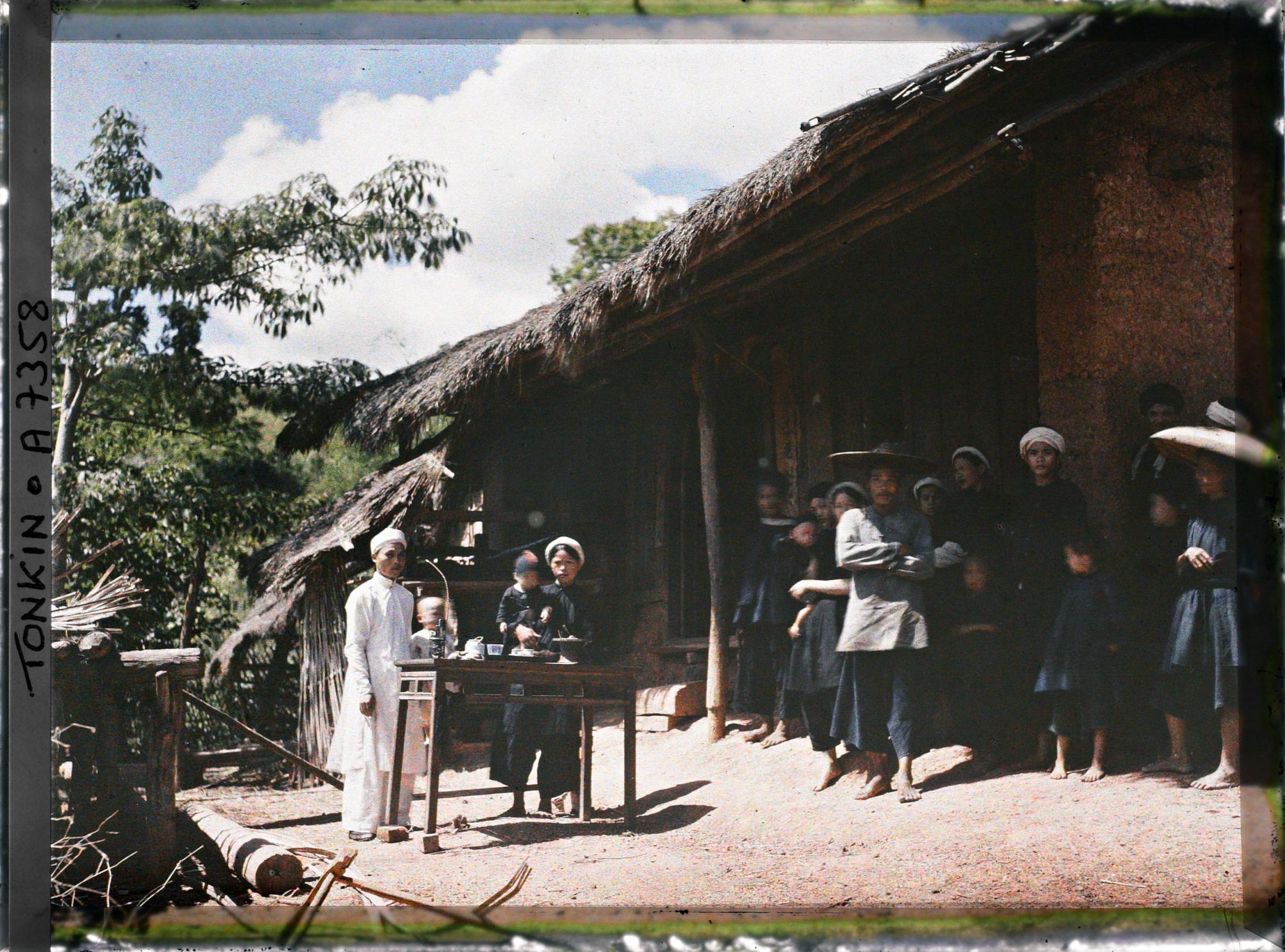Image représentant Le chef du village thô et sa famille, devant leur habitation
