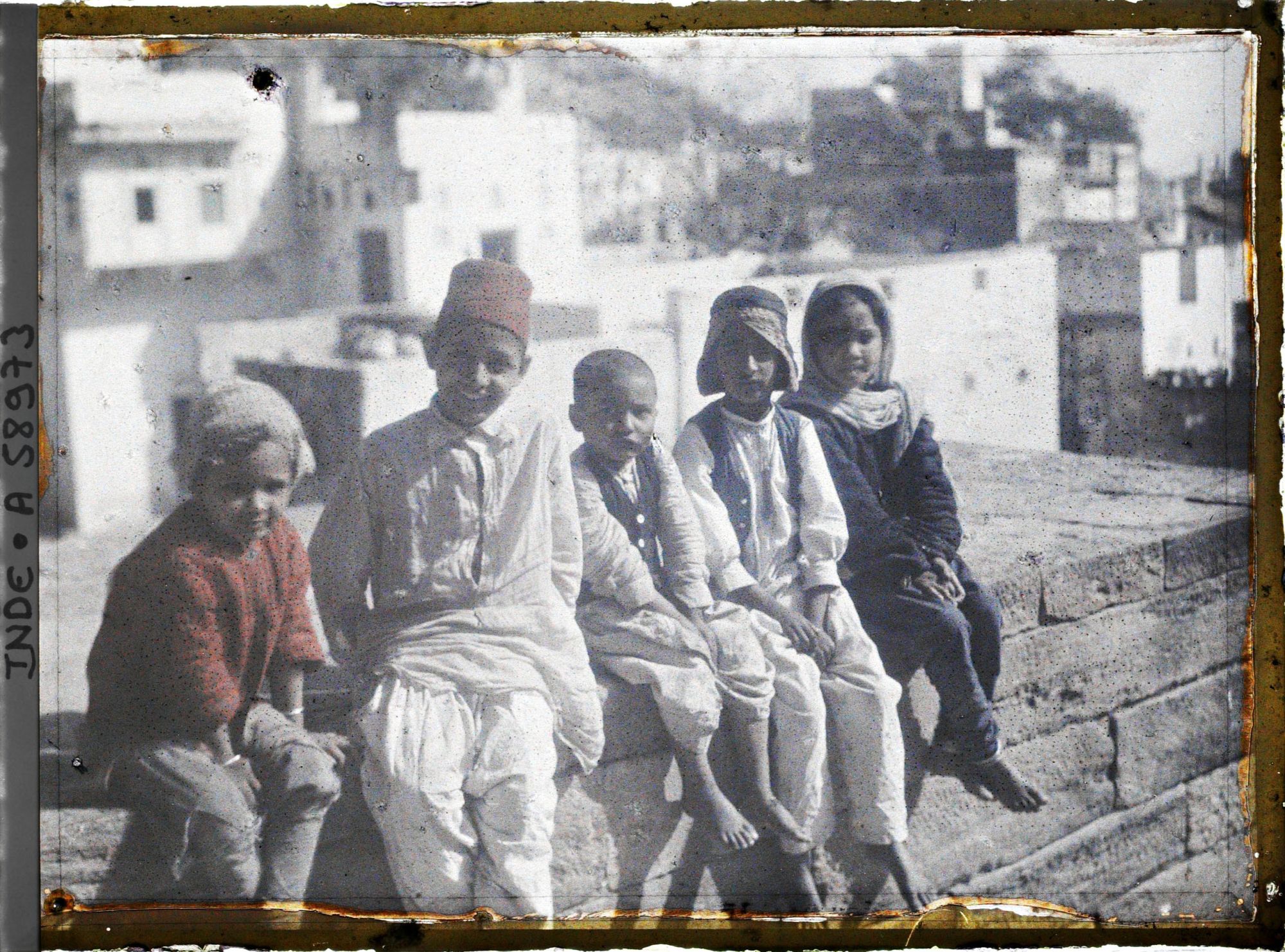 Image représentant Groupe d'enfants musulmans assis sur le muret d'une terrasse de maison