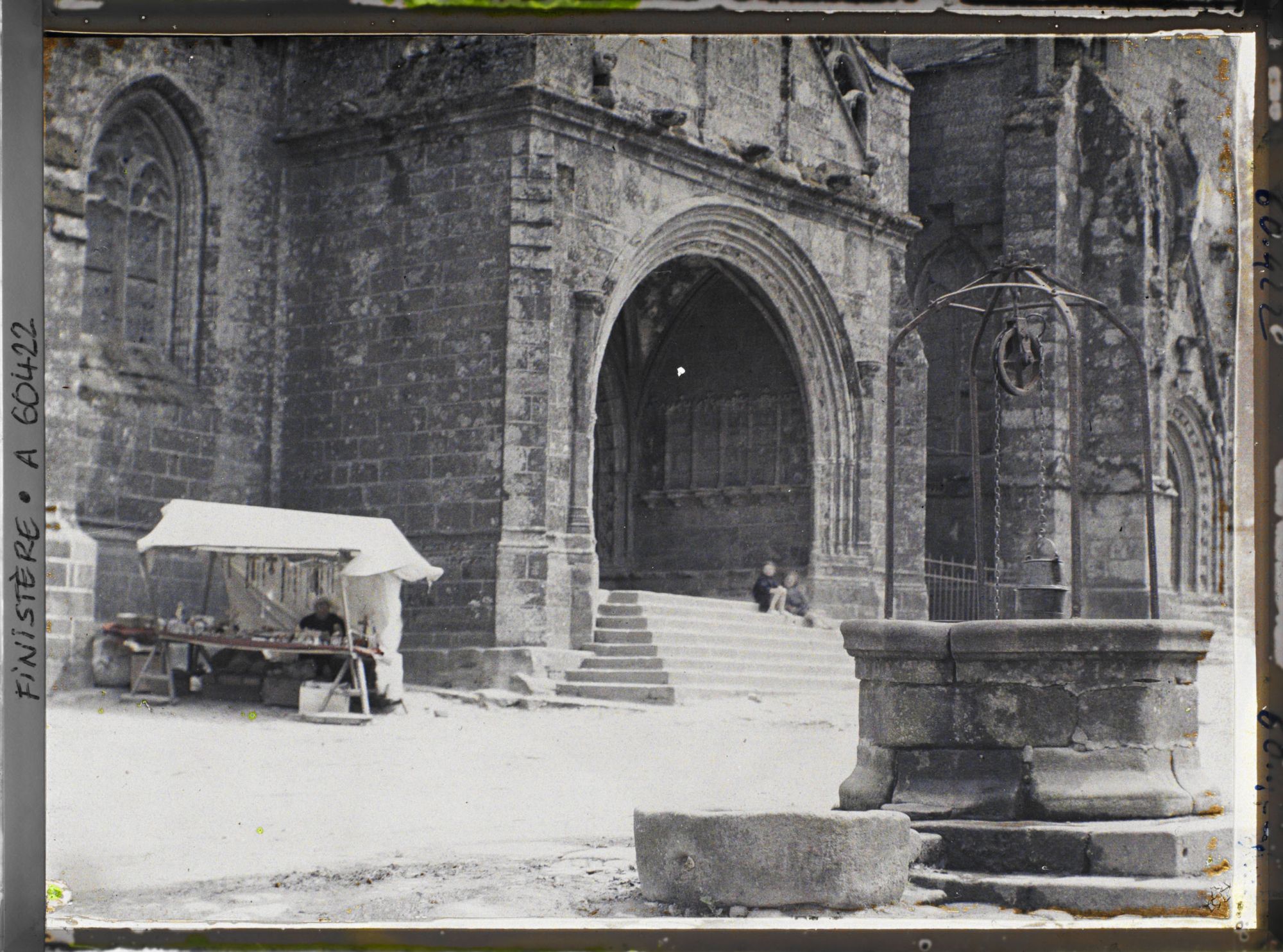 Image représentant Le portail de l'église Saint-Ronan et le vieux puits sur la place de l'Eglise