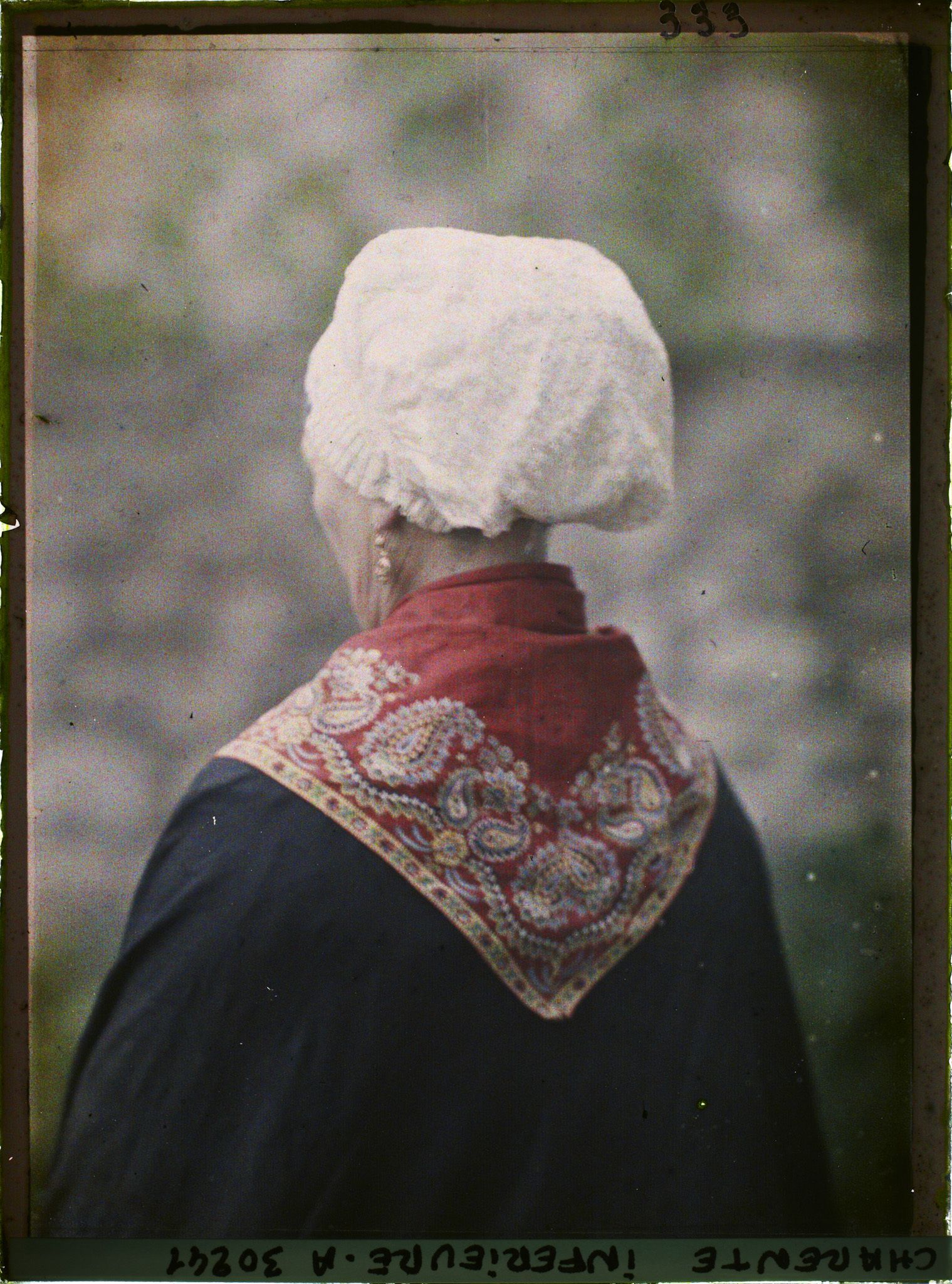 Image représentant Madame Bonnet portant la coiffe rochelaise, de dos