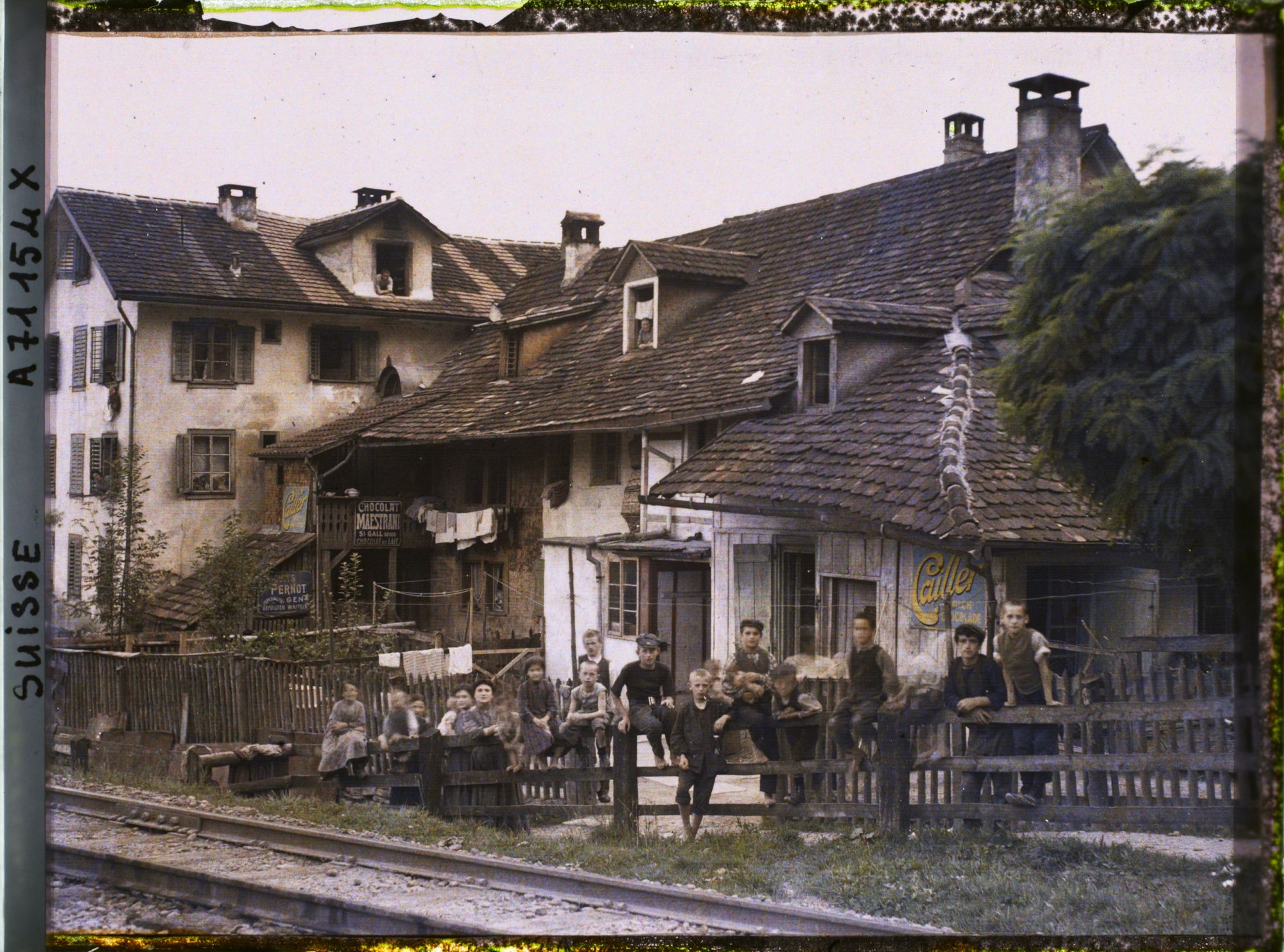 Image représentant Un groupe d'enfants pose devant des habitations au bord d'un chemin de fer