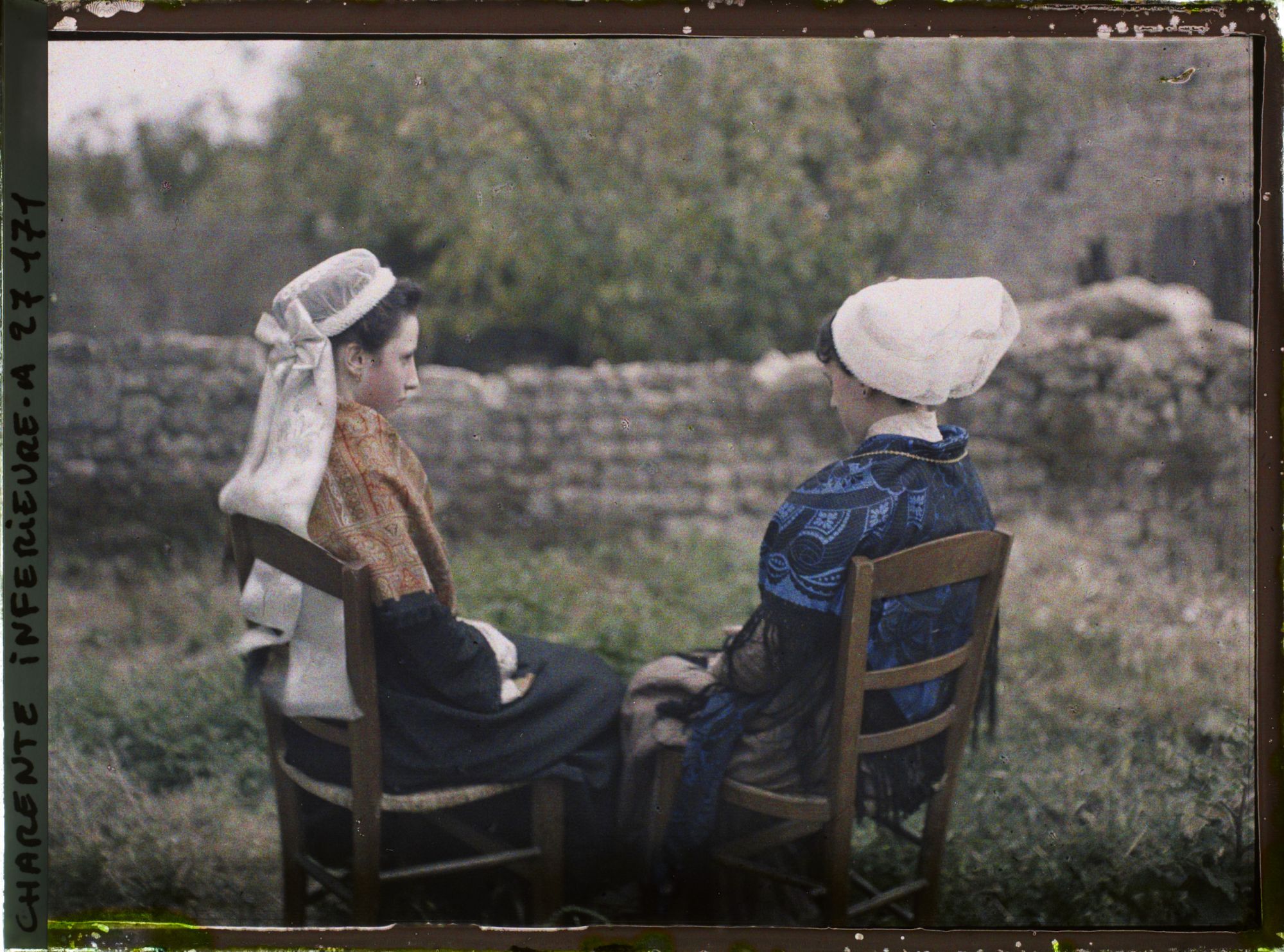 Image représentant Jeunes filles de dos portant coiffes et costumes traditionnels charentais