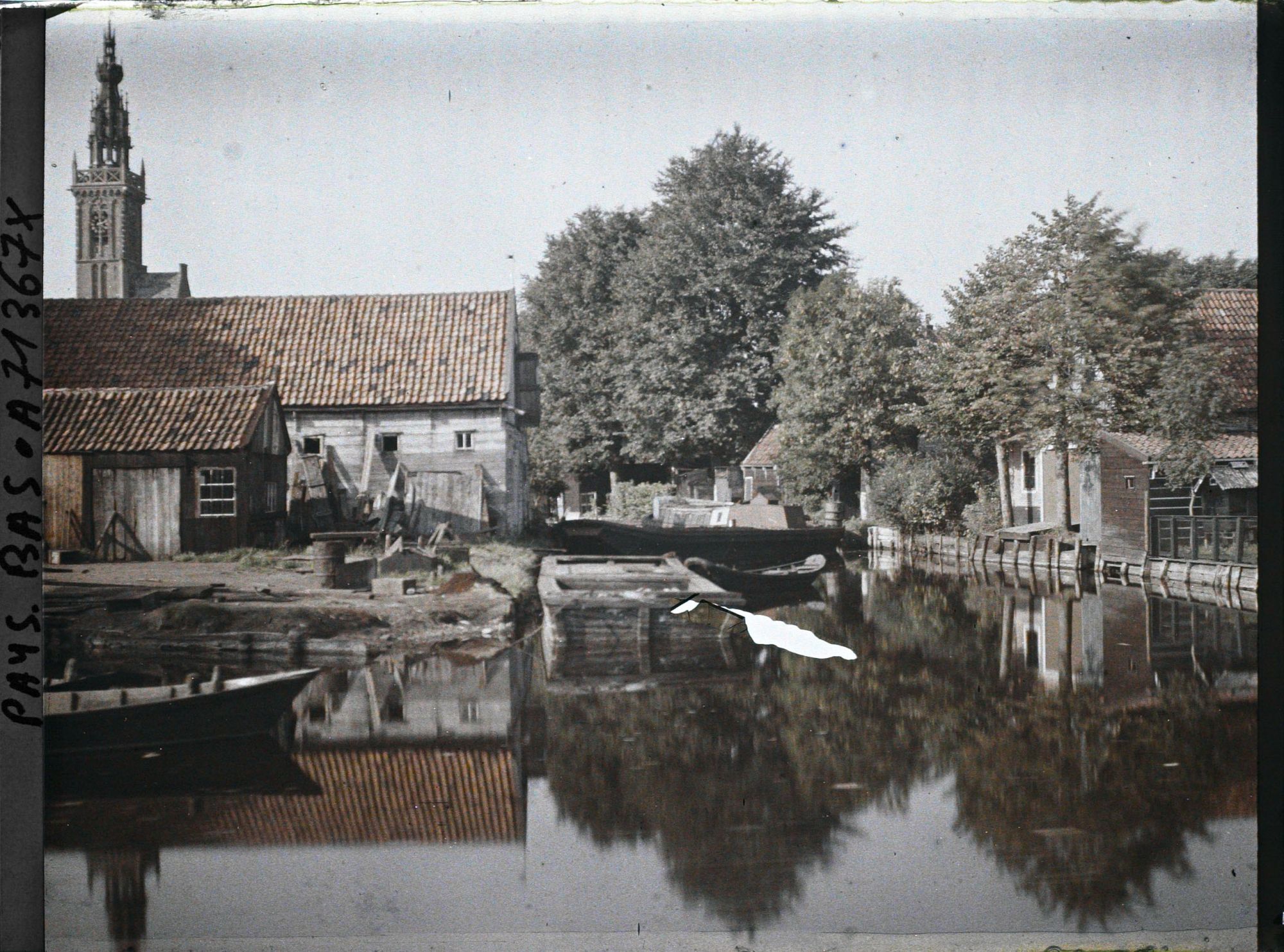 Image représentant Vue d'un canal dans le village ; à l'arrière-plan la tour de l'Horloge