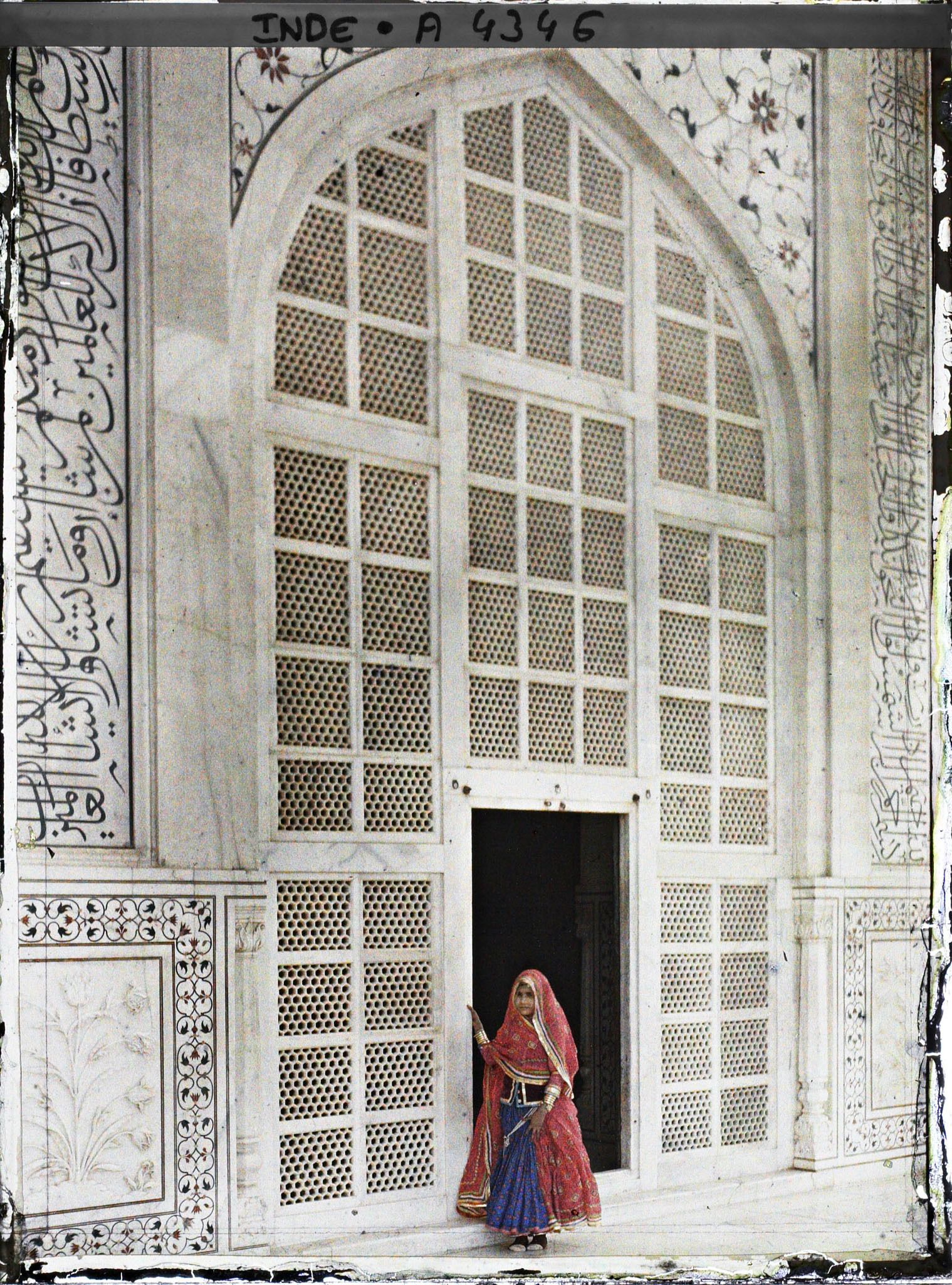 Image représentant Femme portant jupe ample (ghagra) et grand châle (odhni) ramené sur la tête, à la porte du Taj Mahal