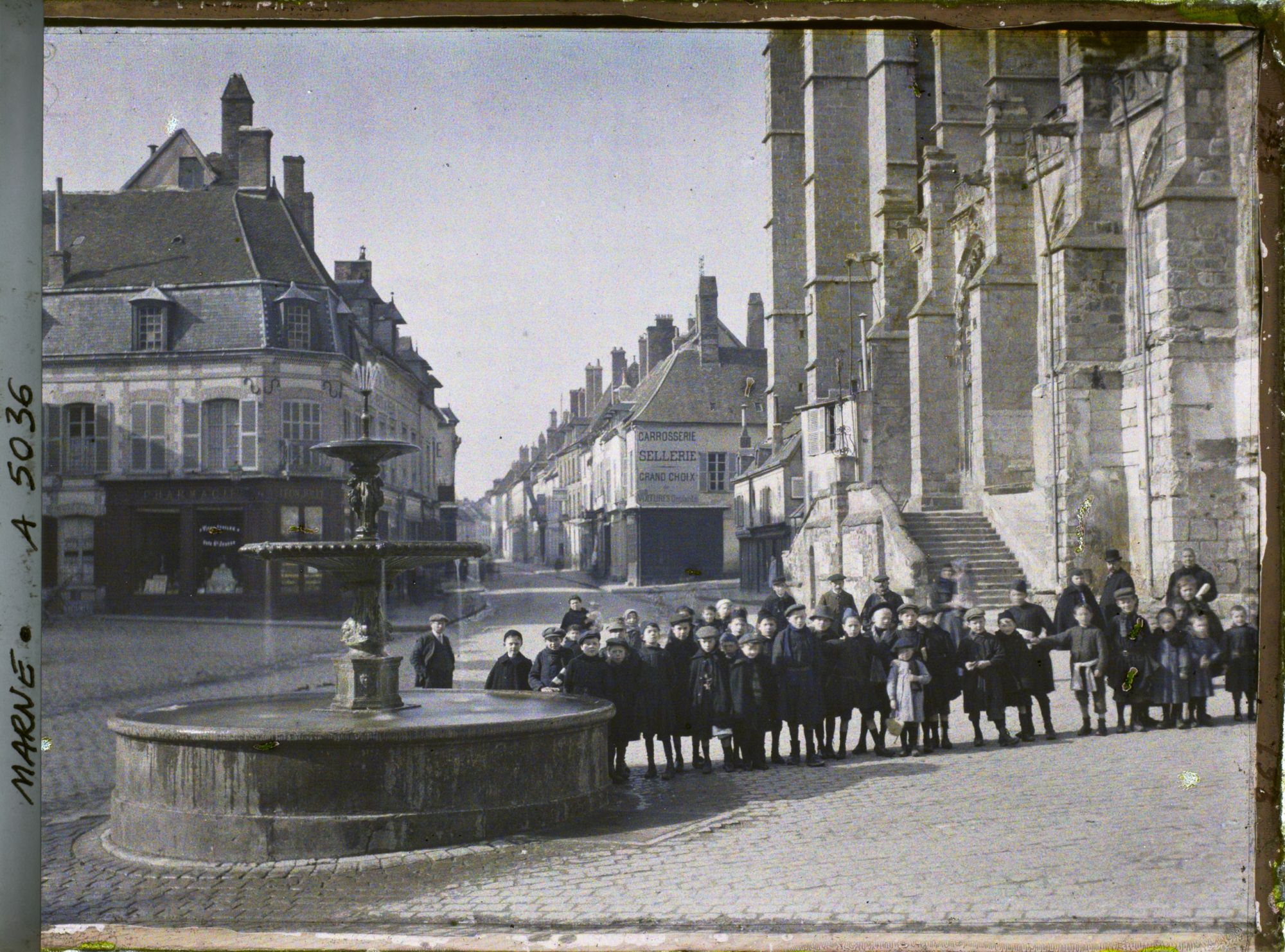 Image représentant Groupe d'enfants posant à côté de la fontaine et de l'église, place de la République