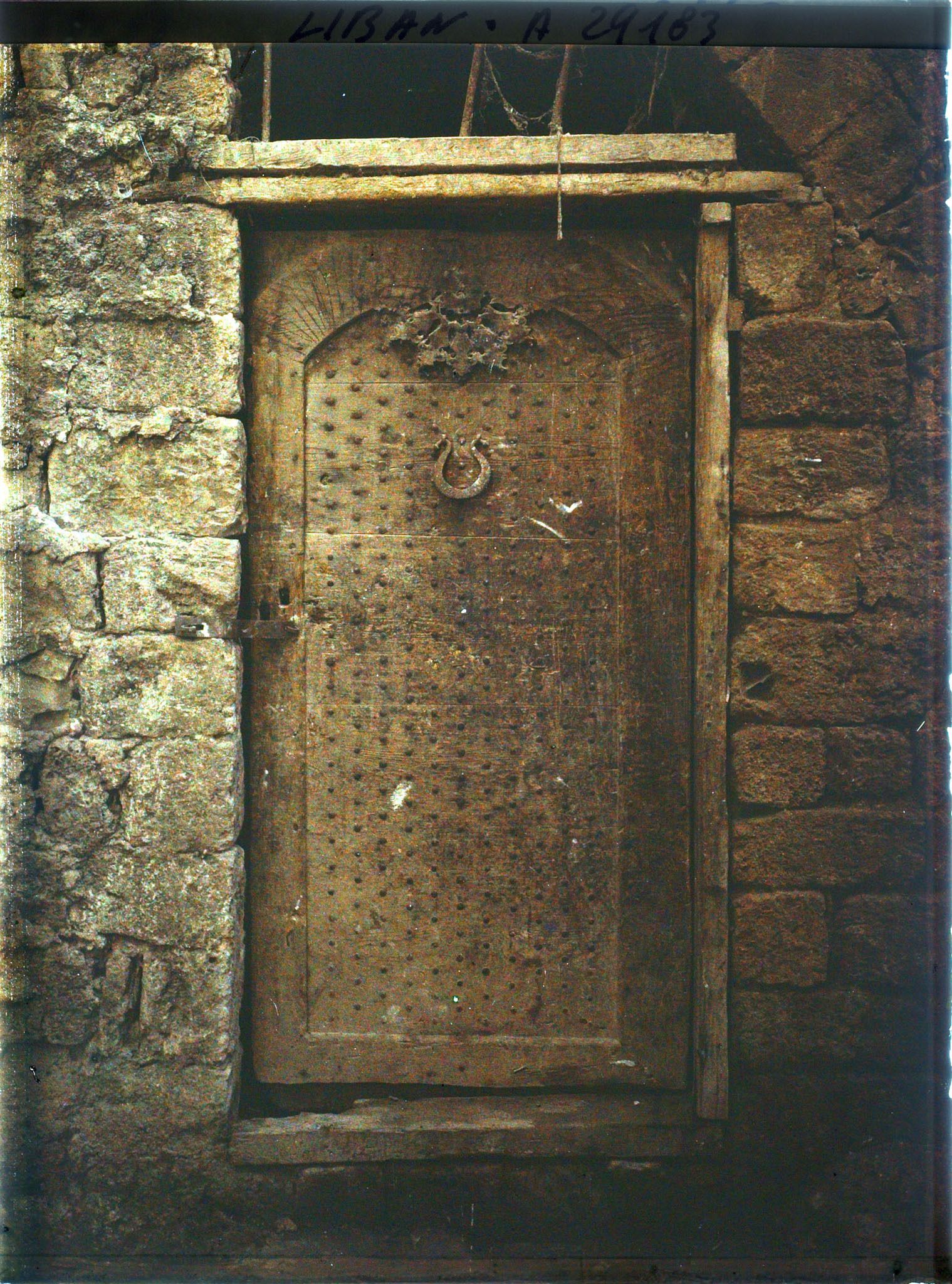 Image représentant Porte ancienne de bois clouté dans une cour d'église