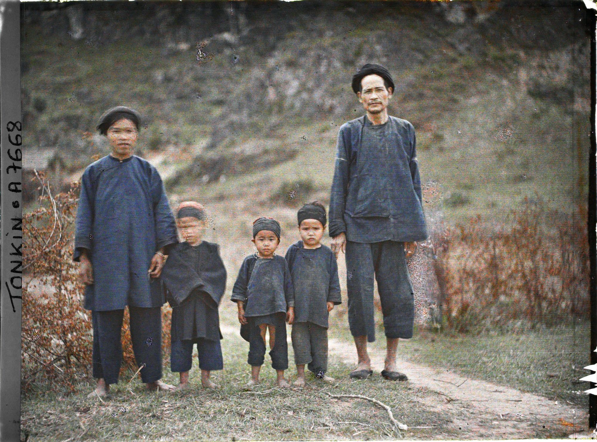 Image représentant Une famille thaï, vêtue de bleu, près des grottes de Ky-lu'a