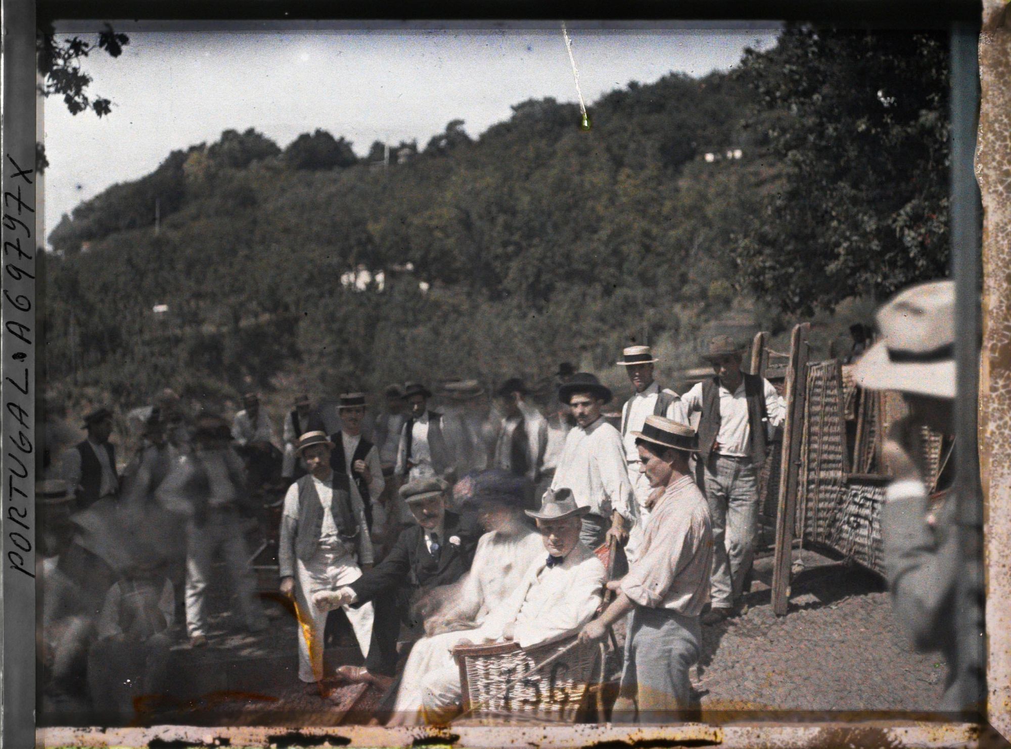 Image représentant Touristes (dont Auguste Léon de face ?) assis dans un traîneau en osier ("carros de cesto do Monte" tiré par des "carreiros")