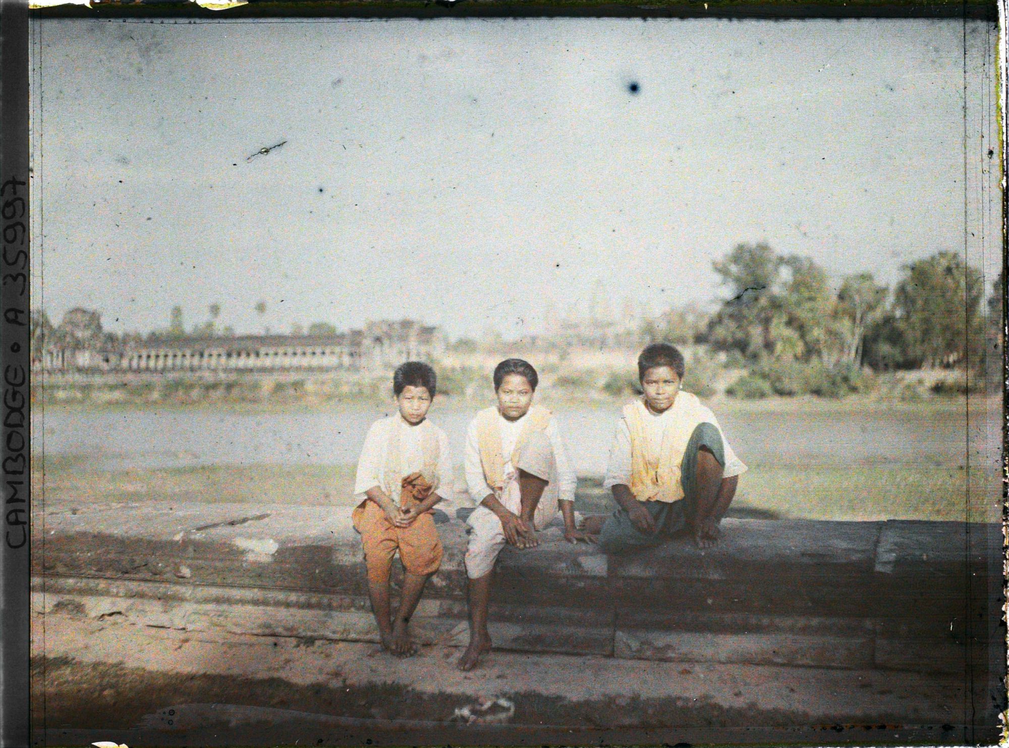 Image représentant Des enfants assis au bord de la douve protégeant l'enceinte extérieure du temple d'Angkor Vat