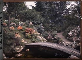 Image représentant Pont du " sanctuaire japonais " reliant un chemin bordé de roches à une rive fleurie d'azalées