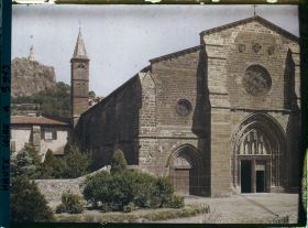 Image représentant La façade et le clocher de l'église Saint-Laurent, avec à l'arrière-plan, le rocher de la Vierge et la statue de Notre-Dame-de-France