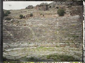 Image représentant Sanctuaire d'Apollon. La scène et les gradins du théâtre qui domine tout le haut du sanctuaire