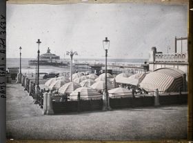 Image représentant La terrasse du Café de la Plage, sous le Kurhaus, qui ouvre sur Le Boulevard ou Strandweg, avec à l'arrière-plan, la jetée promenade
