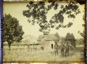 Image représentant Trois hommes somba devant un tata (case) et une plate-forme à sécher le mil