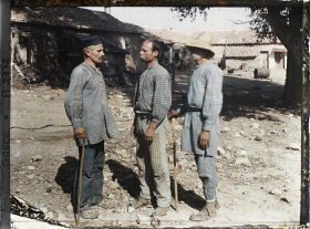 Image représentant Trois paysans (d'origine albanaise) - de profil - dans une cour de ferme