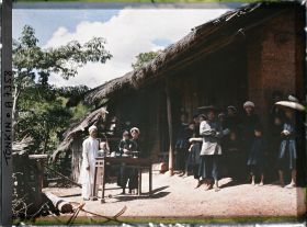 Image représentant Le chef du village thô et sa famille, devant leur habitation