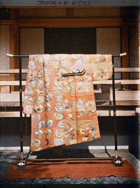 Image représentant Costume de théâtre Nô : kosode en kara-ori à motifs d'éventails et de fleurs présenté sur un iko