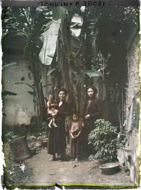 Image représentant Deux femmes et des enfants dans un coin de cour planté de bananiers