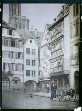 Image représentant France Alsace, Strasbourg, La place des Cochons de lait avec une Alsacienne