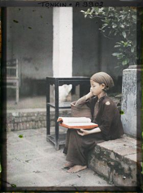 Image représentant Une toute jeune novice lisant dans la cour du temple Vien-minh
