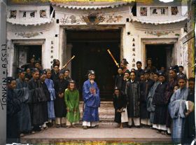 Image représentant Le chef de canton et les autorités villageoises réunis devant le Dinh (maison communale)