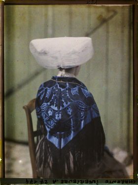 Image représentant Jeune fille de dos portant coiffe et costume traditionnel charentais