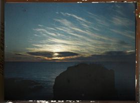 Image représentant Coucher de soleil sur la mer. Au premier plan, des rochers face aux Grottes aux Pigeons