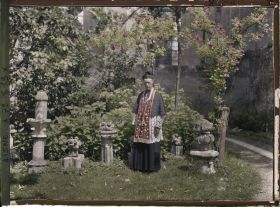Image représentant Monseigneur Landais, archiprêtre de la cathédrale posant près d'une statue