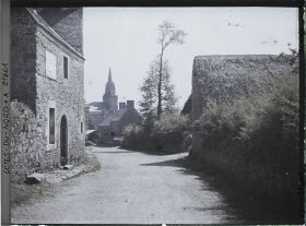 Image représentant L'entrée du village, avec à l'arrière-plan l'église Saint-Yves