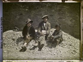 Image représentant Trois enfants espagnols assis sur des cailloux